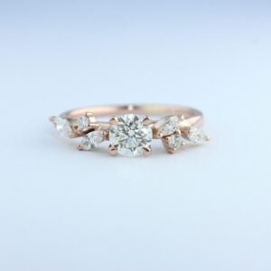 18CT ROSE GOLD SET WITH A ROUND BRILLIANT CUT CENTRE DIAMOND AND MARQUISE CUT DIAMONDS #3976